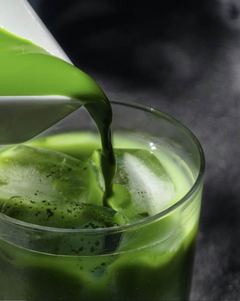 Bright green matcha being poured over ice